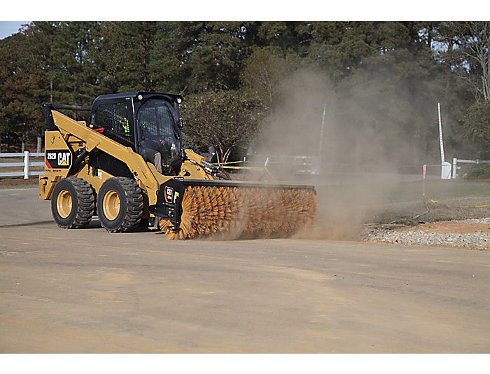 Skid steer loader CAT 262D cleaning pavement with broom